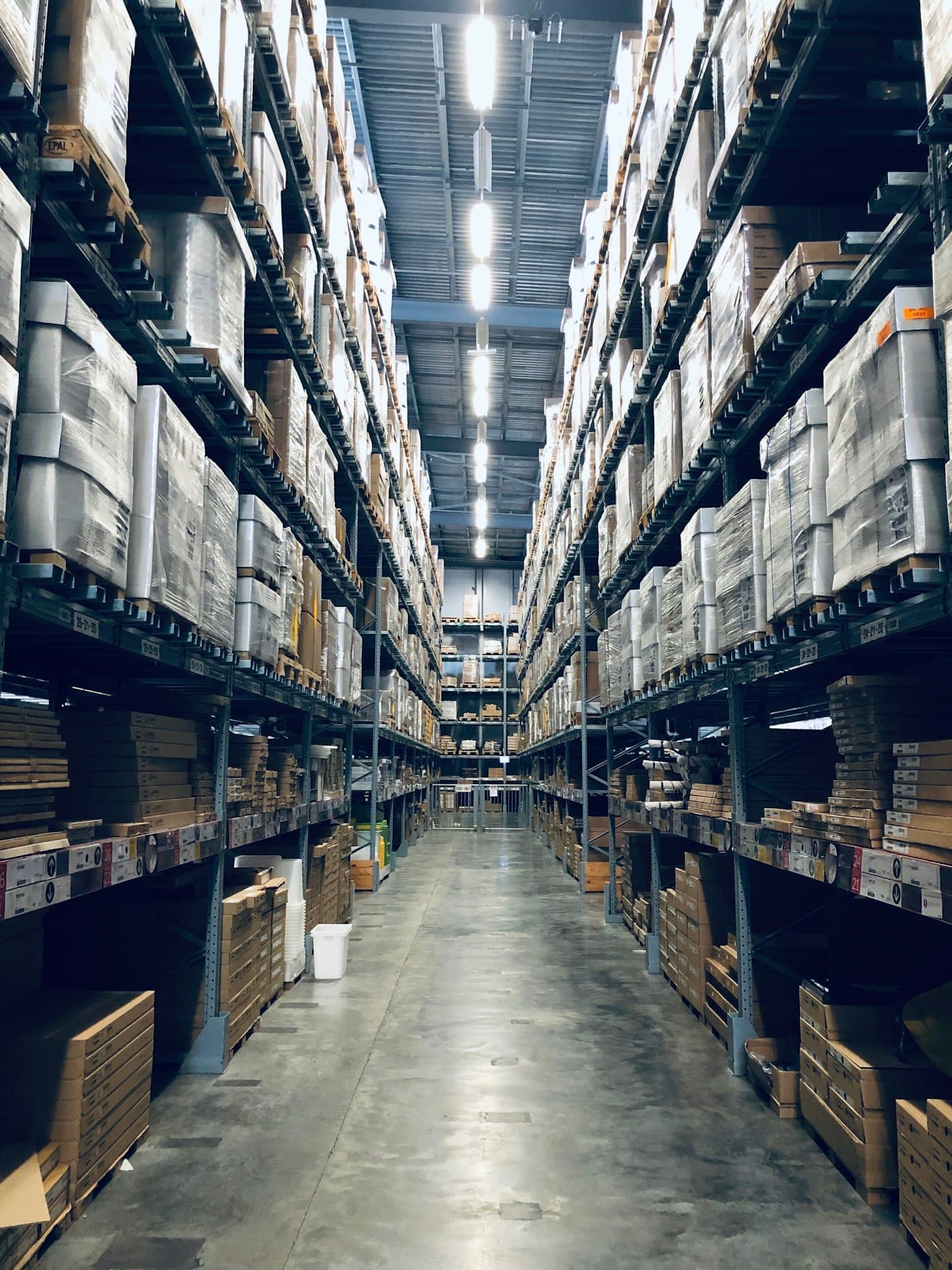 Warehouse aisle with high racking and overhead structure